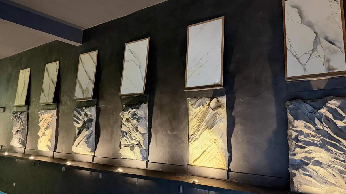Parede grafite do estúdio com quadros de efeito mármore e painéis de rocha esculpida iluminados por baixo